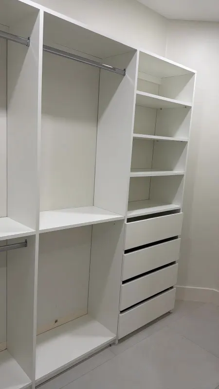 Closet with drawer unit. White modules with hanging space, a column of drawers and adjustable shelves.