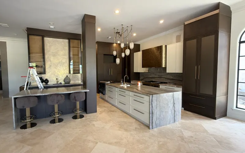 Kitchen with breakfast bar. Tall units in dark wood, an island with white drawers and a separate counter for meals.