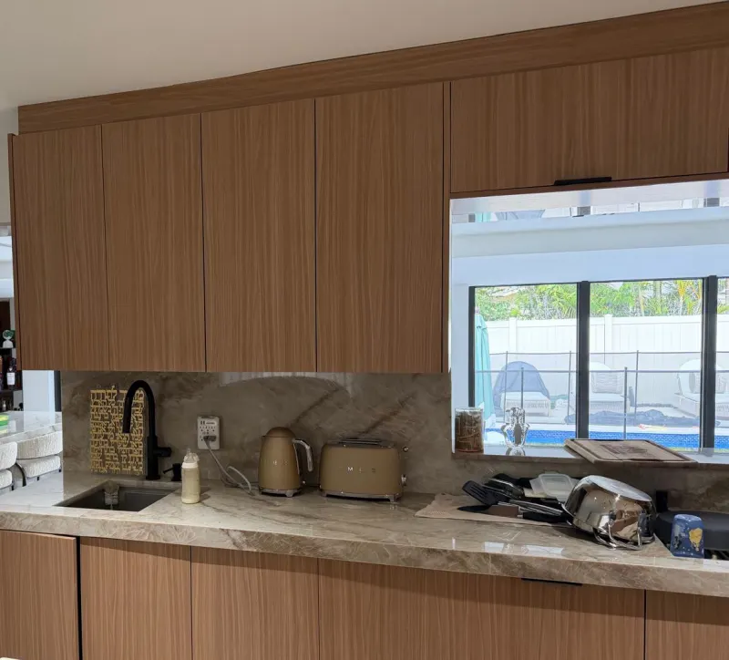 Wood-finish kitchen. Flat-front upper cabinets up to the ceiling and base cabinets in the same wood finish.